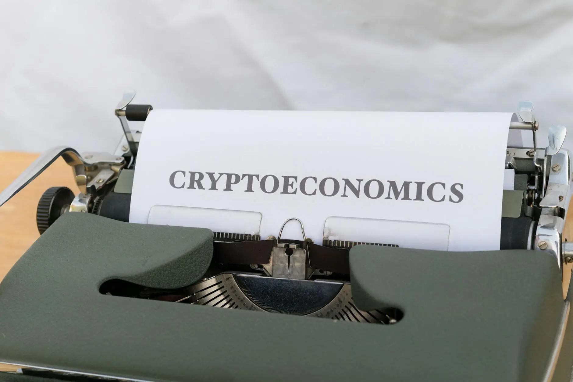 A vintage typewriter with a sheet of paper stating 'CRYPTOECONOMICS'.