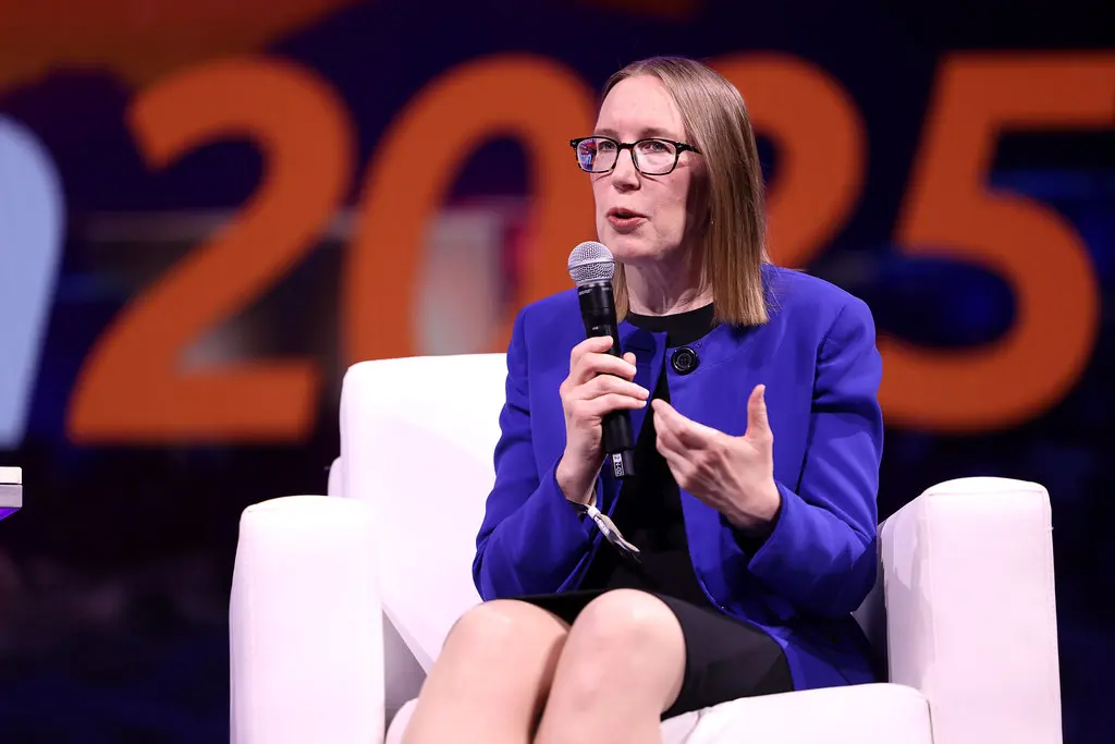 Hester Peirce in einem blauen Blazer spricht in ein Mikrofon während einer Veranstaltung.