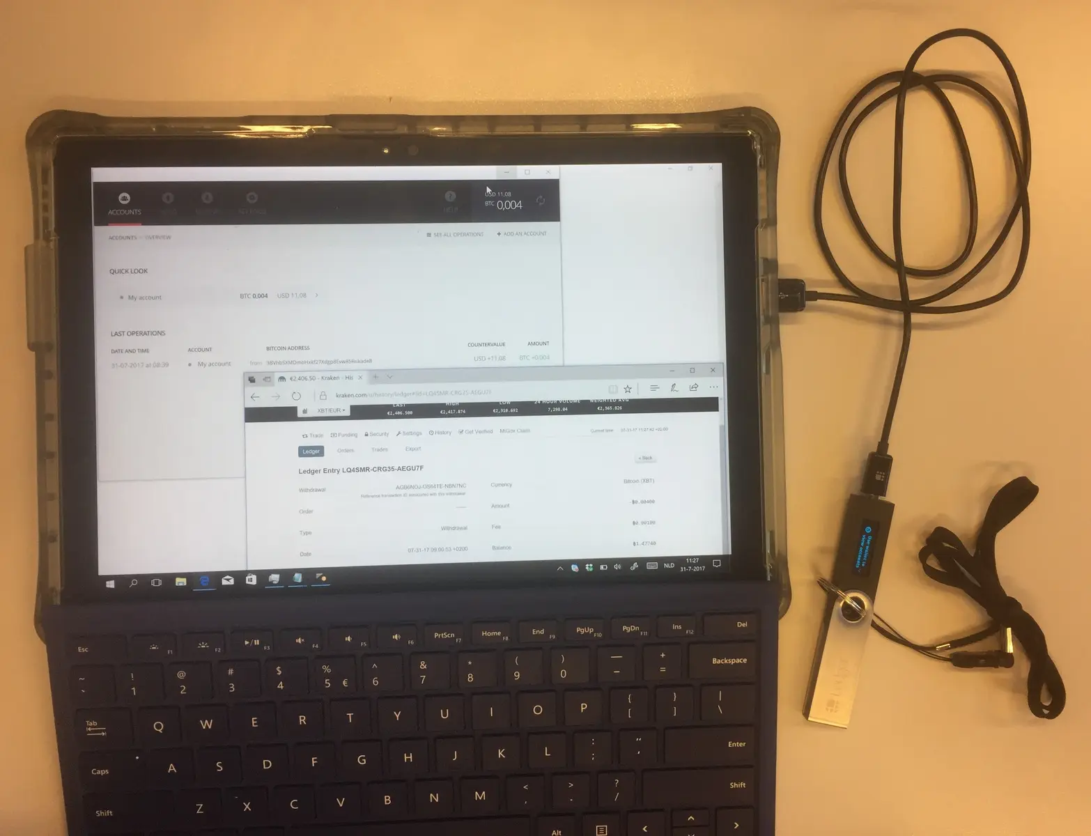 Ein Laptop zeigt die Benutzeroberfläche der Kryptobörse Kraken und eine Transaktion zu einem Ledger-Wallet.