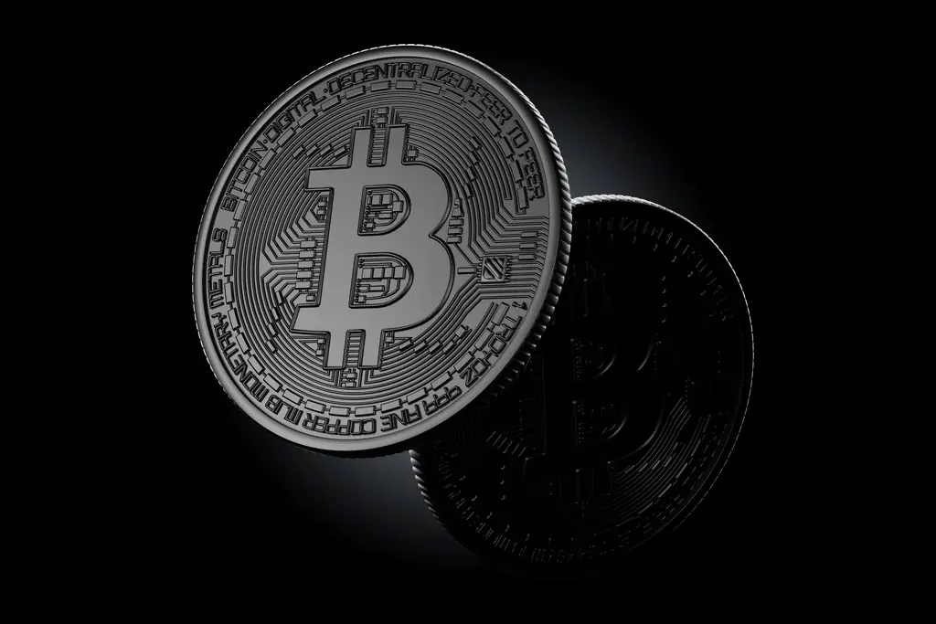 Zwei physische Bitcoin-Münzen auf schwarzem Hintergrund