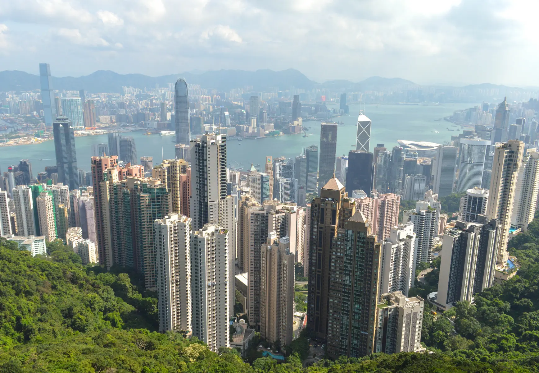 Panorama der Skyline von Hongkong mit zahlreichen Wolkenkratzern und Blick auf den Victoria Harbour.