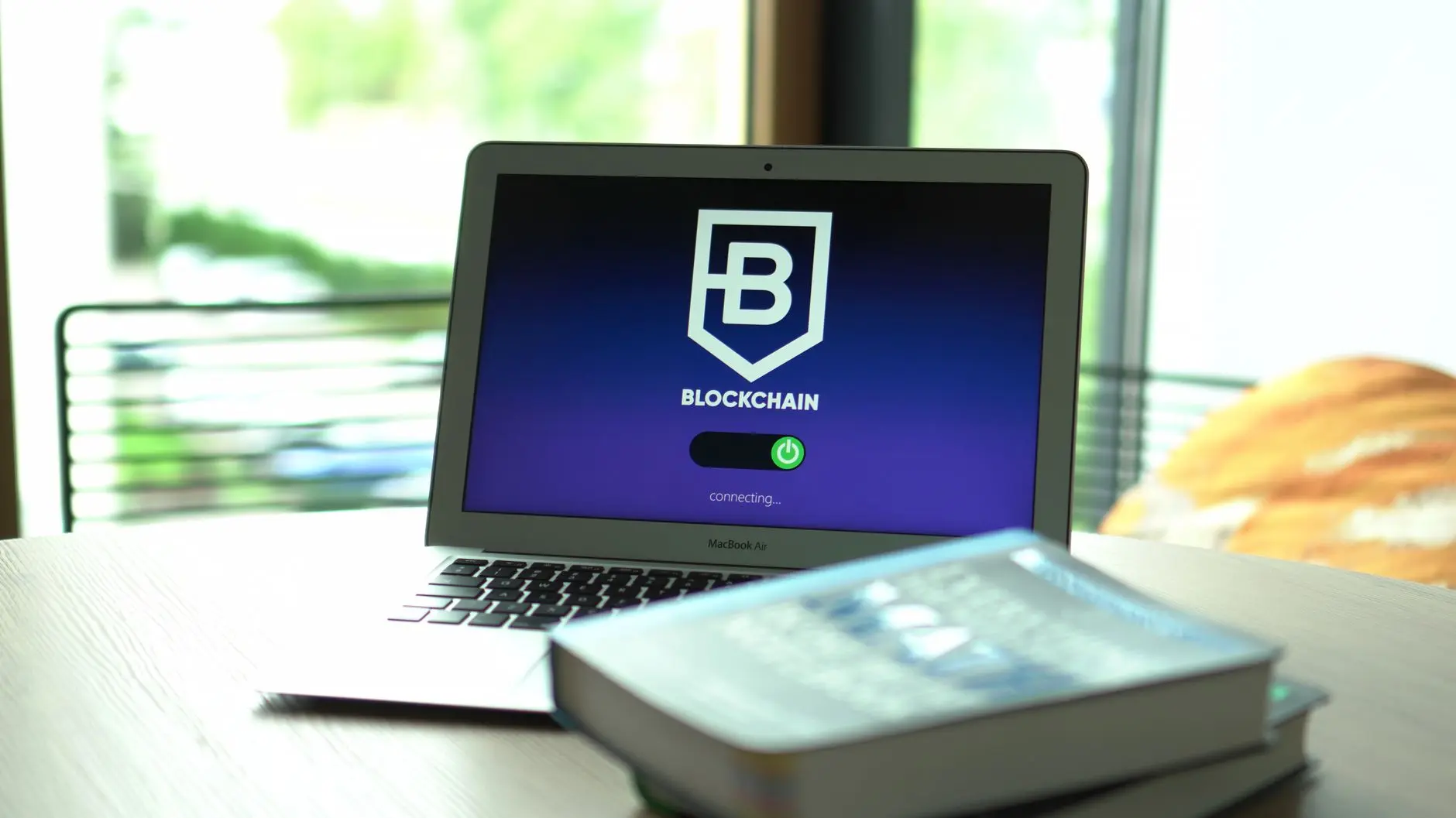 Laptop displaying a blockchain login screen on a wooden table.