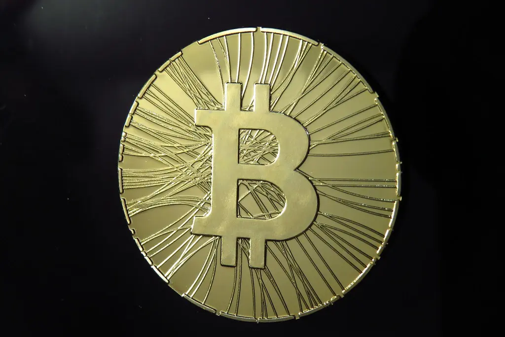 Een gouden Bitcoin-munt met het kenmerkende B-symbool tegen een zwarte achtergrond.