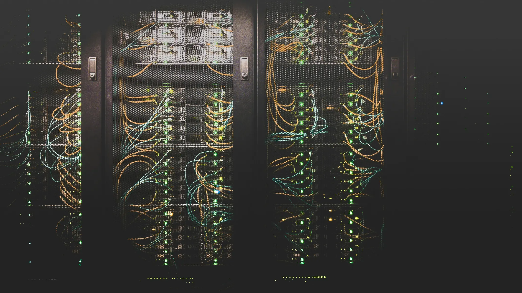 Een overzicht van serverracks met kleurrijke netwerkkabels in een datacenter