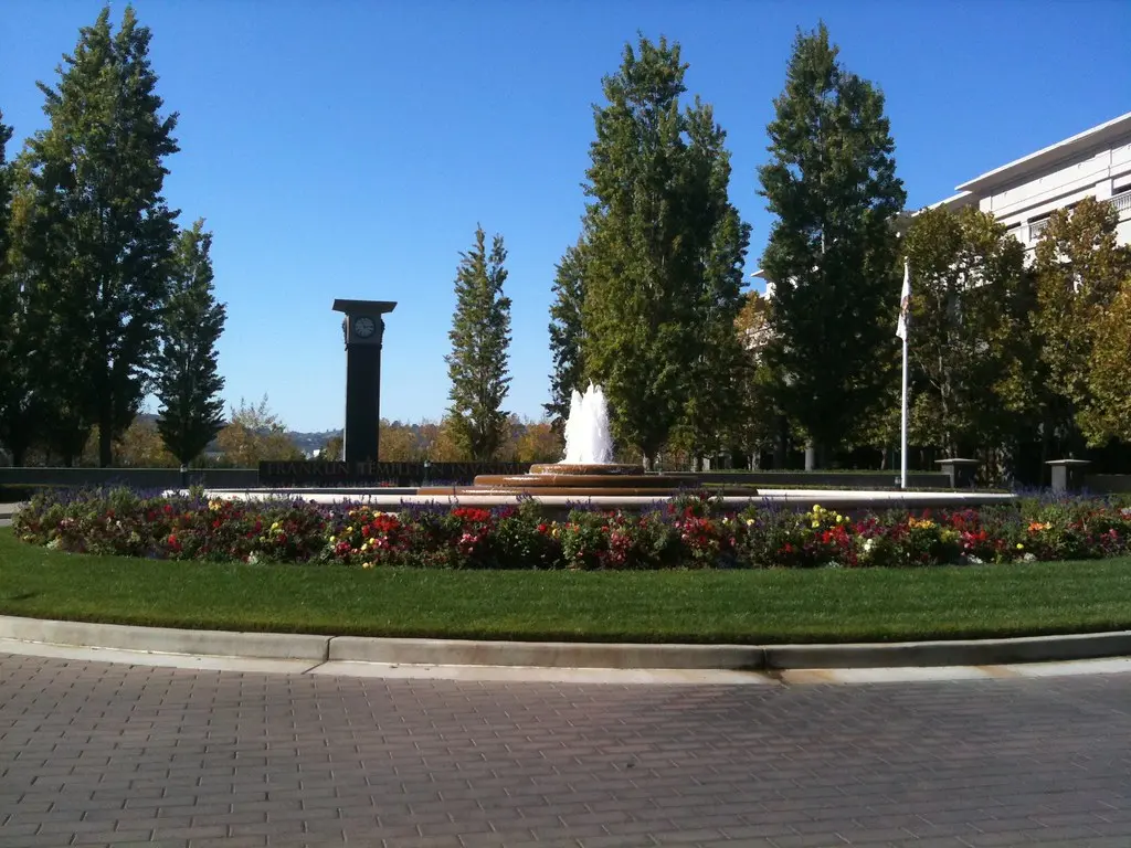Het hoofdkantoor van Franklin Templeton in San Mateo met een fontein en bloembedden op de voorgrond.