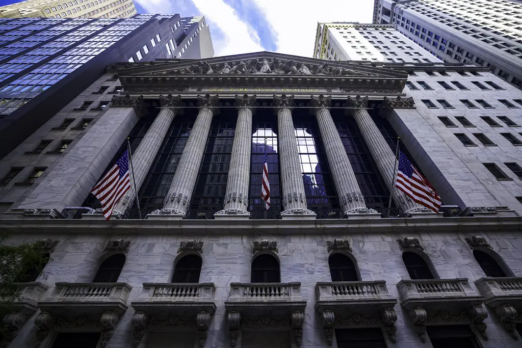 Een groothoekopname van de voorgevel van het New York Stock Exchange-gebouw met Amerikaanse vlaggen.