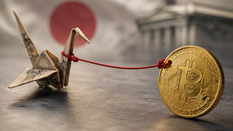 Bitcoin tethered to a Japanese origami crane with Japan’s flag in the background, symbolizing the link between Bitcoin’s rally and Japan’s looming interest rate decision.